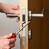 Person using a screwdriver to tighten up a doors loose handles and hinges