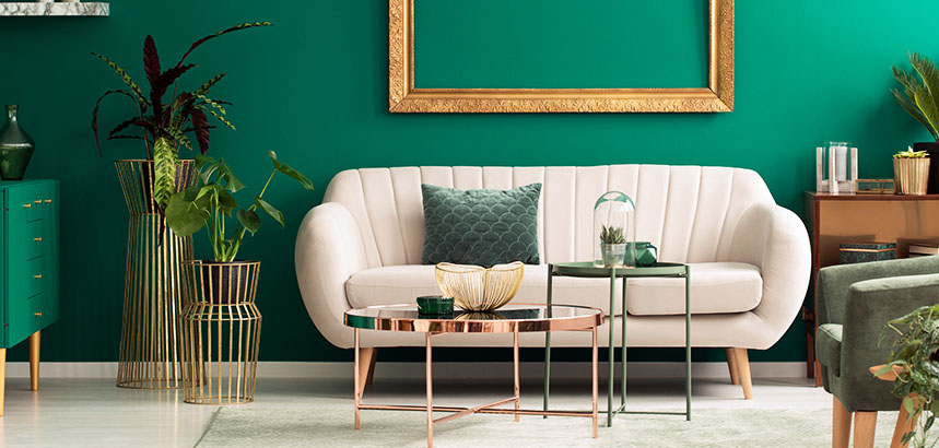 A living room area with a bold green wall and complimentary furniture and decor.